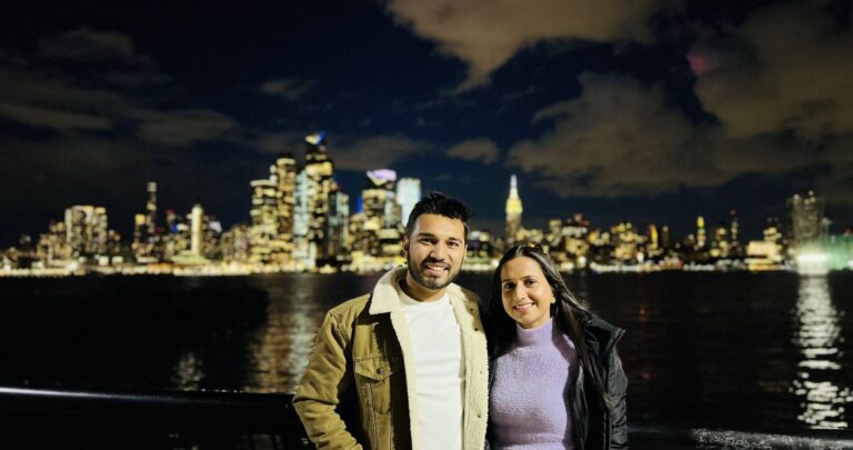 Manhattan skyline at night with illuminated skyscrapers and reflections on the water