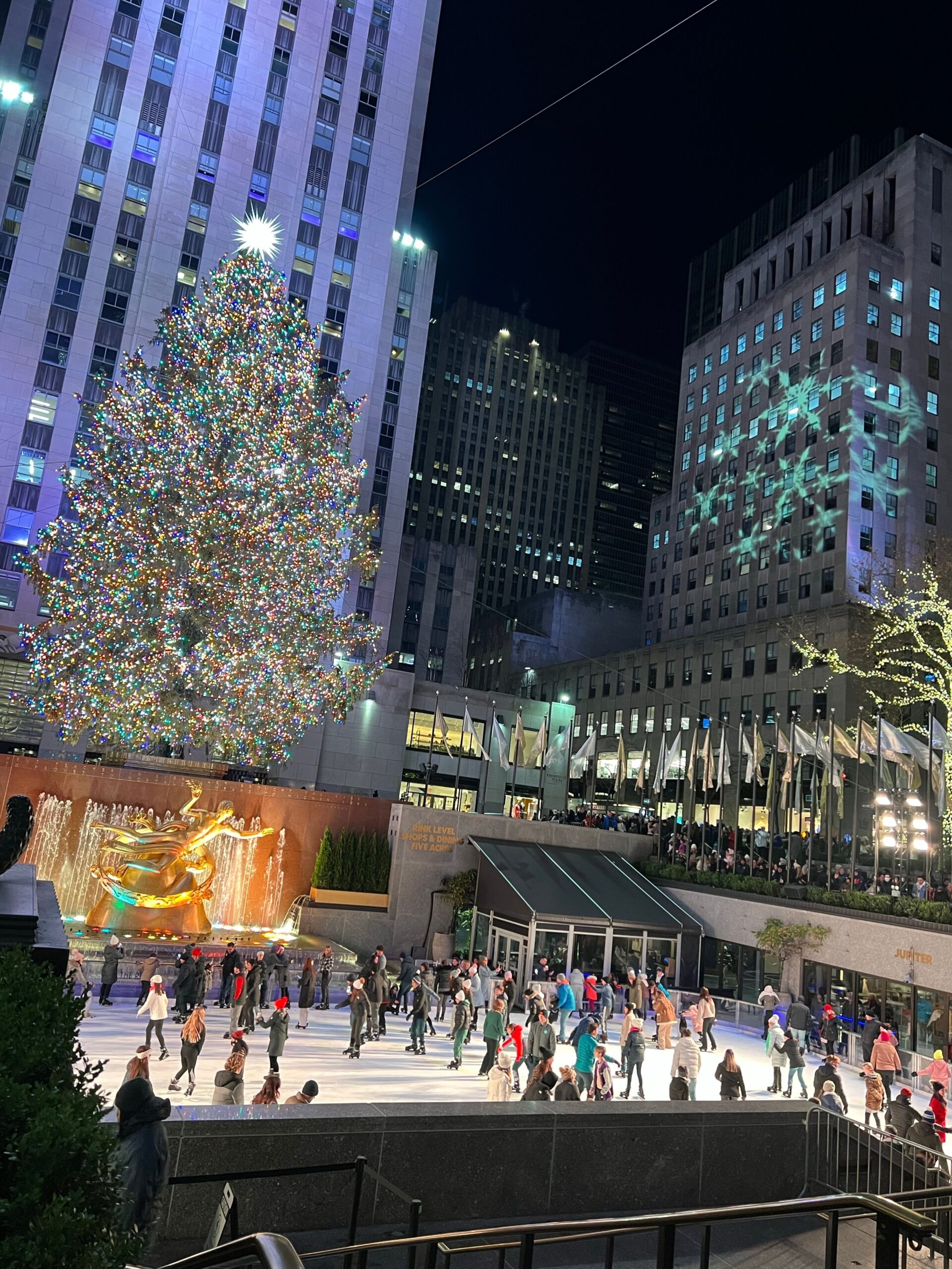 Rockefeller Center in New York City during the holiday season with Christmas tree and city lights