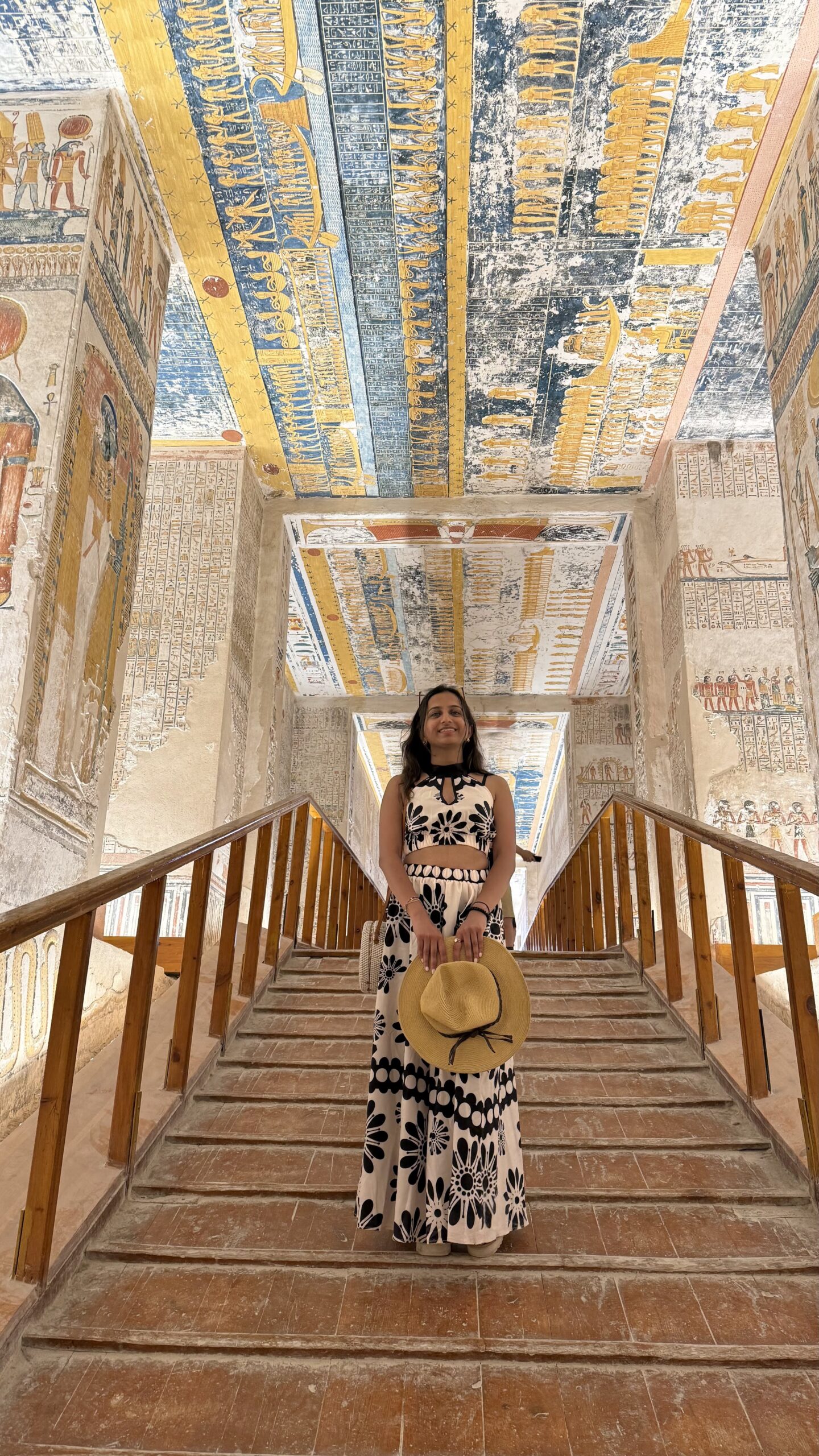 Visitor on stairway inside colorful painted tomb at Valley of the Kings, Luxor