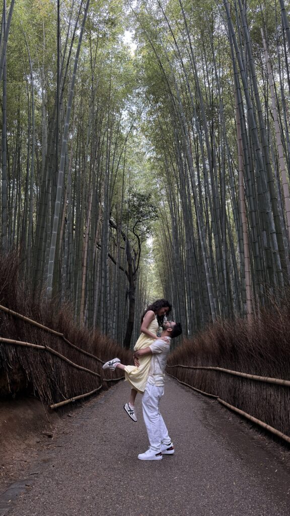 Couple posing playfully on the path through the towering bamboo stalks of the Arashiyama Bamboo Grove, Kyoto